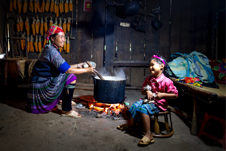 Madre e hija cocinando con combustibles sólidos.